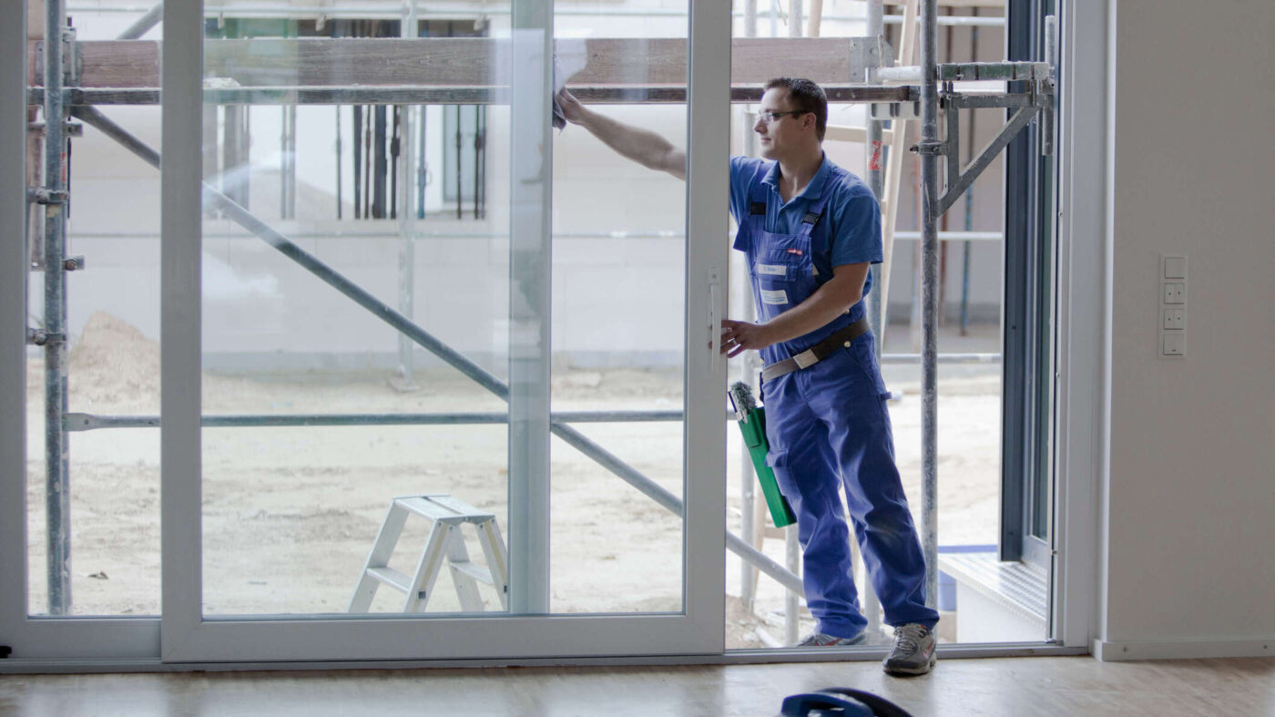 Gebäudereinigung Hannover von der Fiduz Gebäudereinigungs GmbH | Mann reinigt Glasfläche